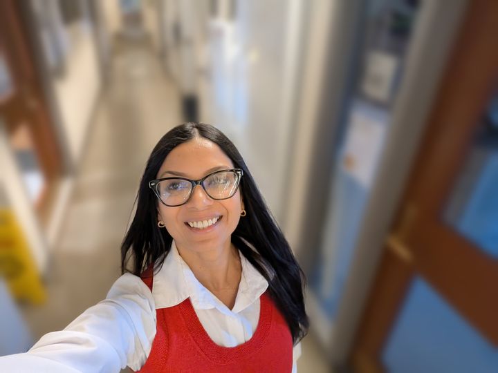 Lekshmi smiling in a building corridor at Harvard